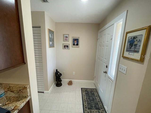 interior space with light tile patterned floors and baseboards