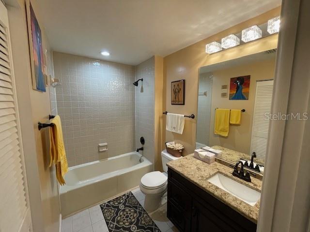 full bathroom featuring vanity, bathing tub / shower combination, toilet, and tile patterned floors