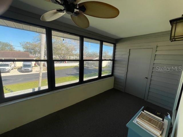 unfurnished sunroom with a ceiling fan