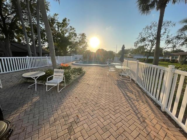 view of community with fence, a pool, and a patio