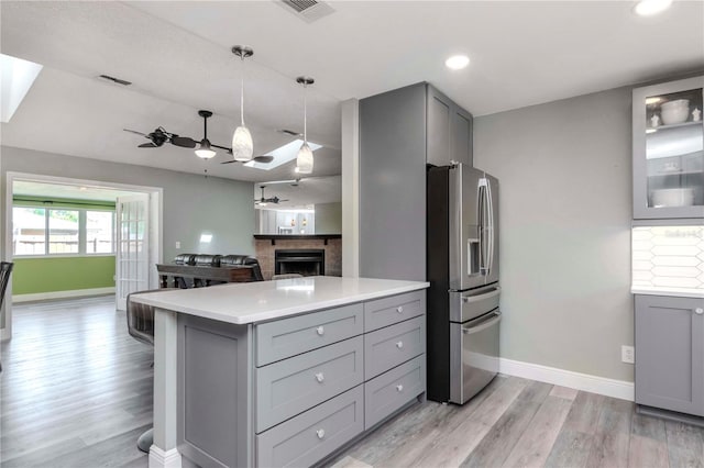 kitchen with ceiling fan, visible vents, stainless steel fridge, and gray cabinetry