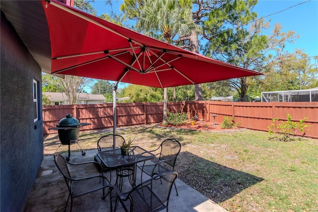 view of yard featuring outdoor dining space, a patio, and a fenced backyard