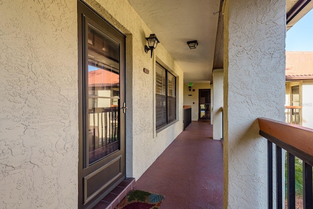 doorway to property featuring stucco siding and a balcony