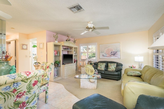 tiled living room featuring visible vents, a textured ceiling, and a ceiling fan