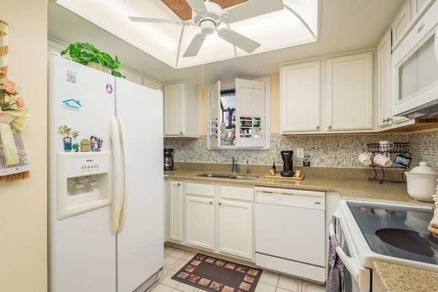 kitchen featuring a sink, decorative backsplash, white appliances, and light tile patterned floors