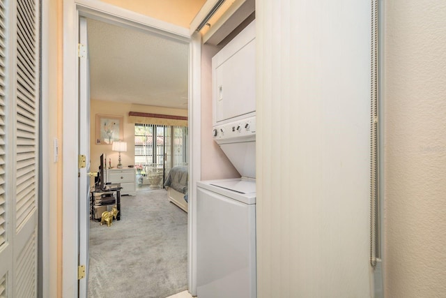 washroom with laundry area, stacked washer and dryer, and carpet flooring