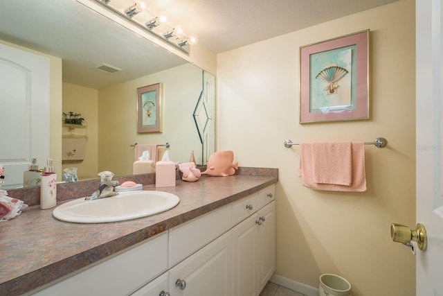 bathroom featuring visible vents, vanity, and baseboards