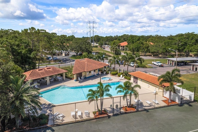 community pool with a gate, fence, a hot tub, a gazebo, and a patio area