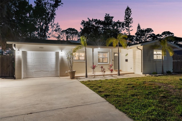 view of front of house with a garage, a front lawn, driveway, and fence