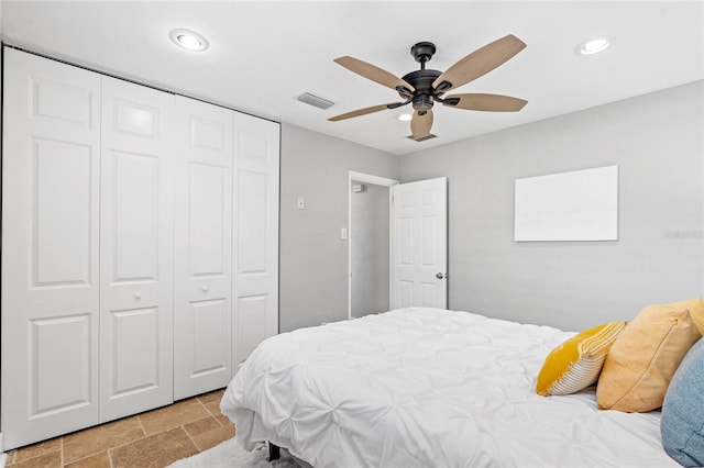 bedroom with a closet, visible vents, recessed lighting, and stone finish flooring