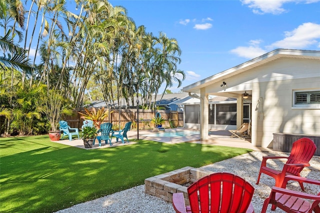 view of yard featuring a patio, a fenced in pool, fence, ceiling fan, and a fire pit