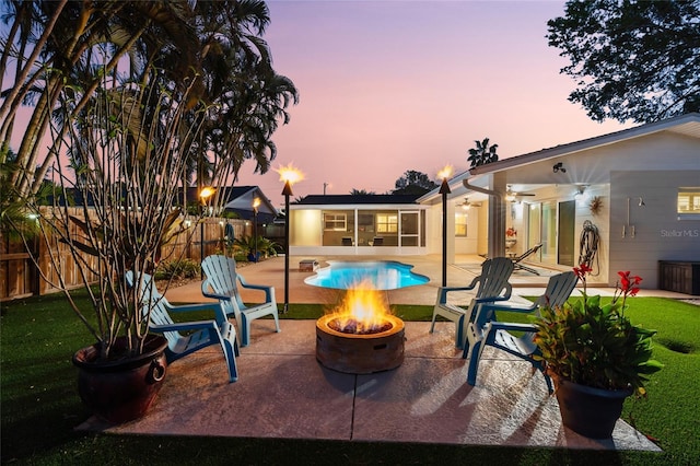 view of patio with a fire pit, fence, a fenced in pool, and ceiling fan