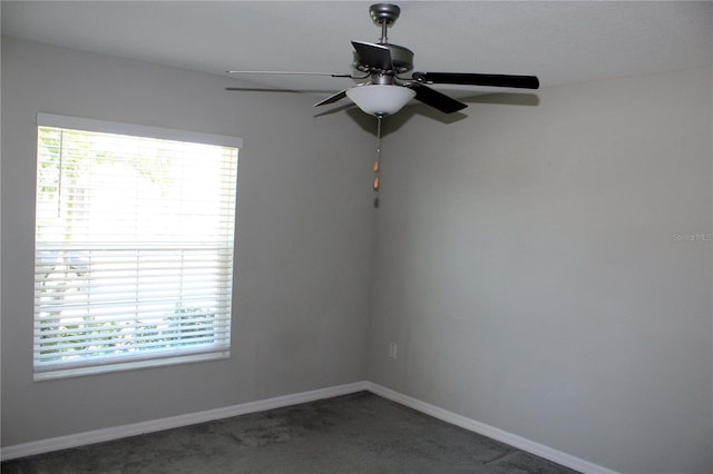 carpeted spare room featuring a ceiling fan, a wealth of natural light, and baseboards