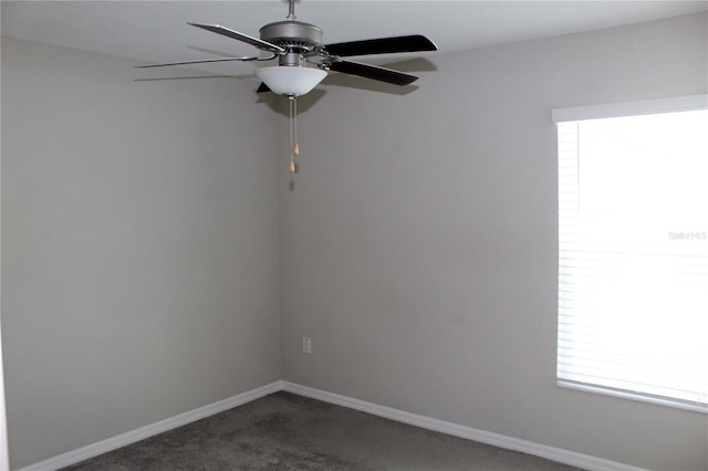 carpeted empty room featuring baseboards and a ceiling fan