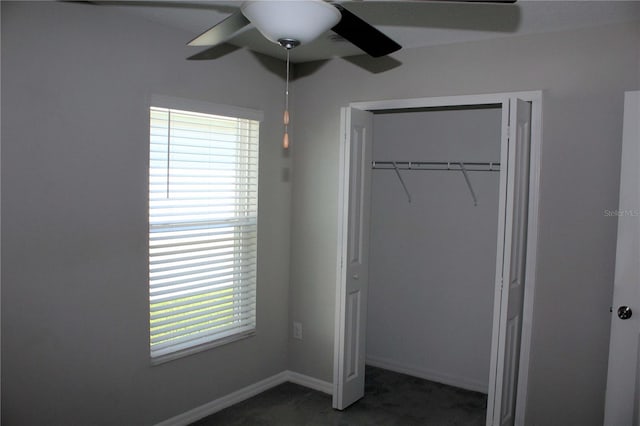 unfurnished bedroom with dark carpet, a closet, ceiling fan, and baseboards