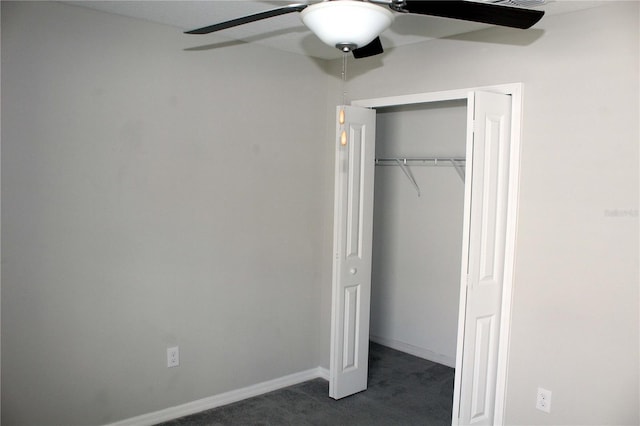 unfurnished bedroom with a ceiling fan, baseboards, dark colored carpet, and a closet