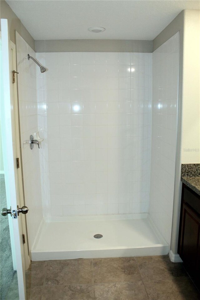 full bathroom with vanity, a shower stall, and tile patterned floors