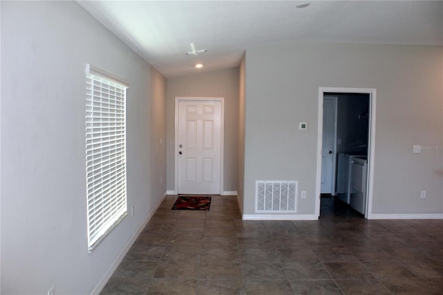 entrance foyer with washing machine and dryer, vaulted ceiling, visible vents, and plenty of natural light