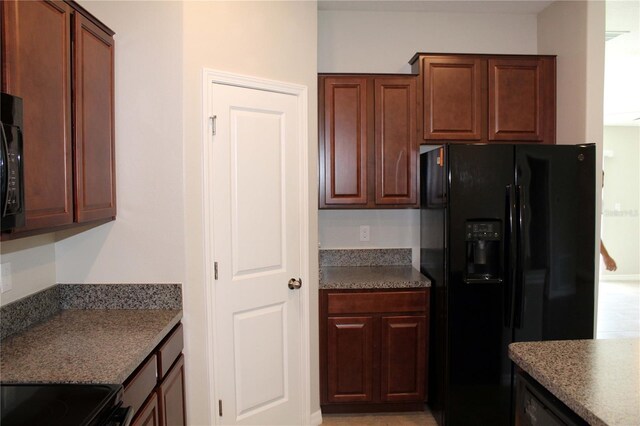 kitchen with black refrigerator with ice dispenser