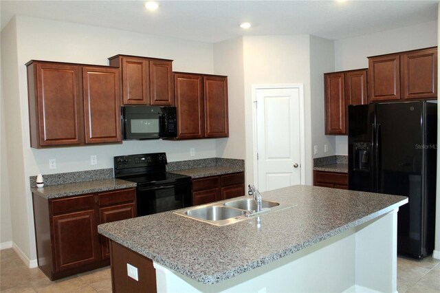 kitchen featuring recessed lighting, a sink, baseboards, black appliances, and a center island with sink