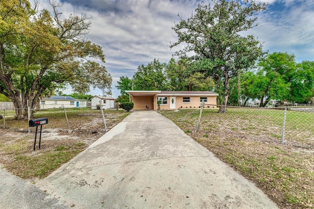 ranch-style home featuring driveway and a fenced front yard