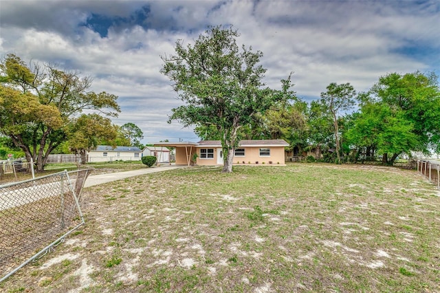 view of front of property with a front yard, fence, a carport, and concrete driveway