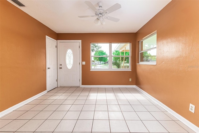 foyer featuring ceiling fan, light tile patterned flooring, visible vents, and baseboards