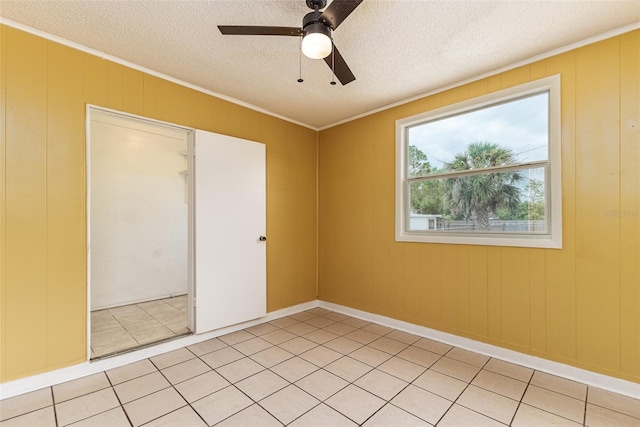 spare room with light tile patterned floors, ceiling fan, ornamental molding, and a textured ceiling