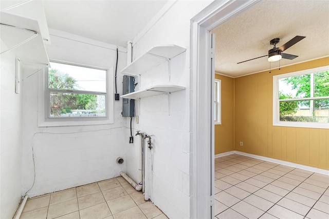 clothes washing area featuring laundry area, electric panel, a wealth of natural light, and a textured ceiling