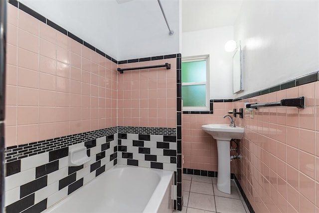 bathroom featuring a wainscoted wall, a sink, tile walls, and tile patterned floors