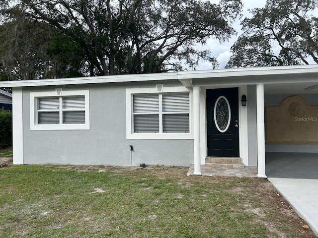 view of front of home featuring stucco siding and a front yard