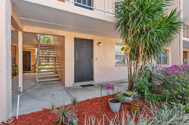 doorway to property featuring a balcony and stucco siding