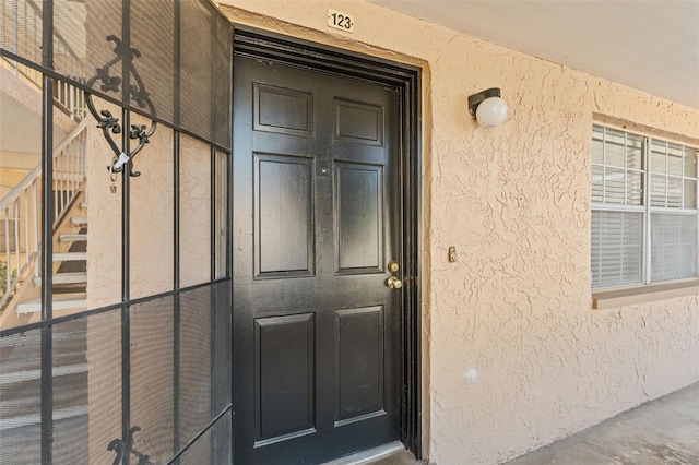 doorway to property featuring stucco siding