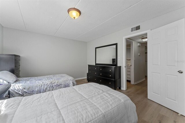 bedroom featuring light wood-style flooring, baseboards, and visible vents