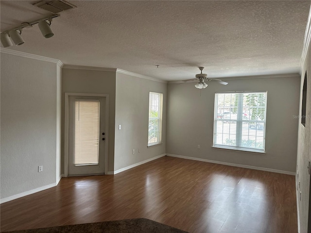 spare room featuring crown molding, plenty of natural light, and wood finished floors