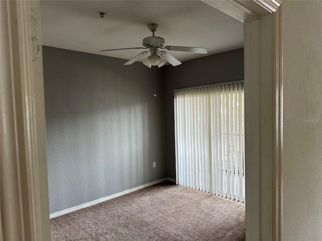 spare room with a textured wall, carpet flooring, a ceiling fan, and baseboards