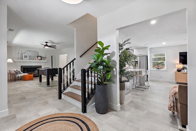 9067 Cypress Trl, Seminole, FL 33777 - stairs featuring ceiling fan, a fireplace, baseboards, and recessed lighting