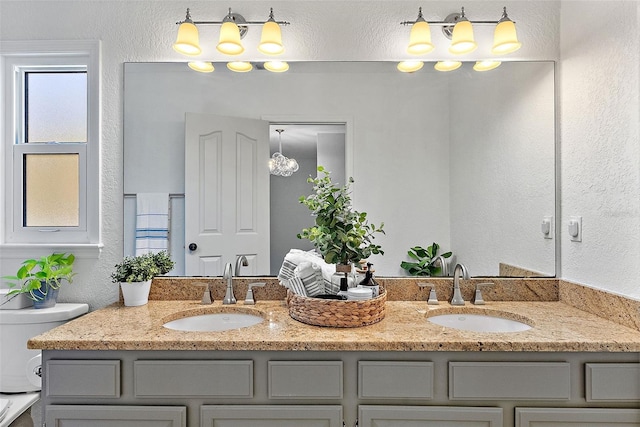9067 Cypress Trl, Seminole, FL 33777 - full bathroom with double vanity, a textured wall, and toilet