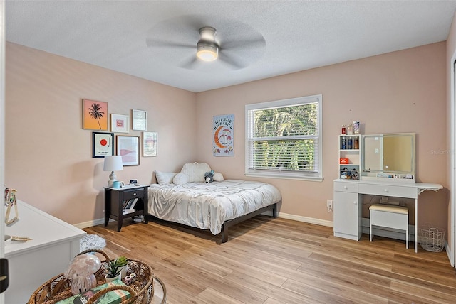 9067 Cypress Trl, Seminole, FL 33777 - bedroom featuring baseboards, light wood-type flooring, ceiling fan, and a textured ceiling