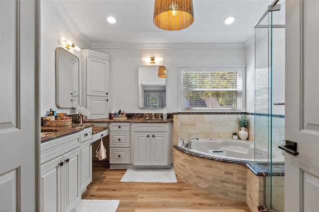 9067 Cypress Trl, Seminole, FL 33777 - bathroom with vanity, a bath, a stall shower, ornamental molding, and wood finished floors