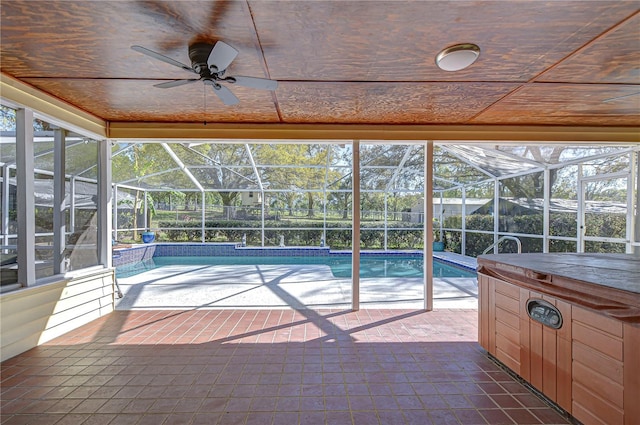 pool with glass enclosure, a hot tub, a patio, and ceiling fan