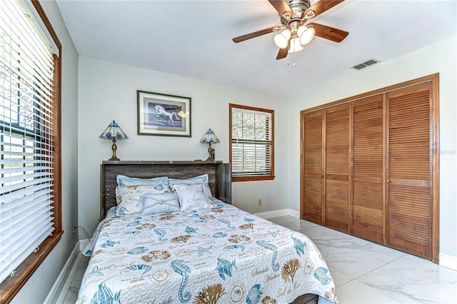 bedroom featuring visible vents, baseboards, ceiling fan, a closet, and marble finish floor