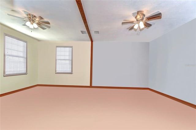 empty room featuring baseboards, visible vents, and ceiling fan