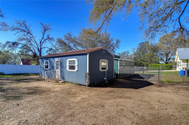 view of outbuilding featuring entry steps and fence