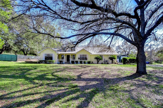 single story home with a front yard and fence