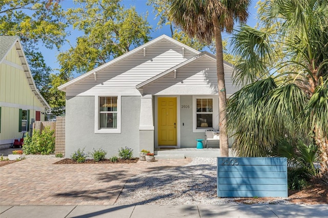 bungalow featuring stucco siding