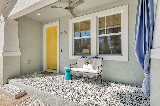 property entrance with stucco siding and a ceiling fan