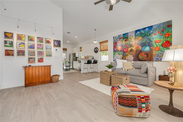 living room featuring baseboards, visible vents, a ceiling fan, and light wood-style floors