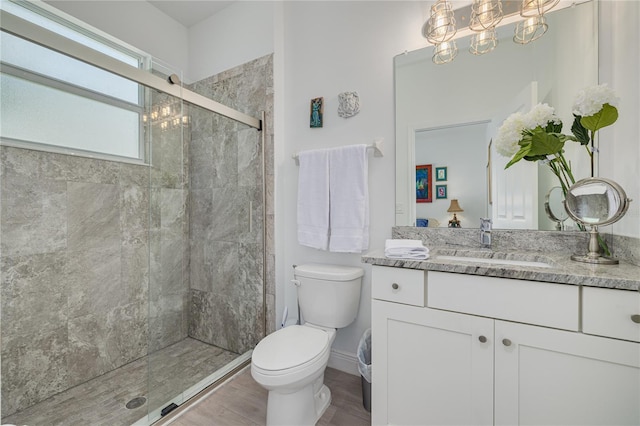 bathroom featuring vanity, baseboards, a shower stall, a notable chandelier, and toilet