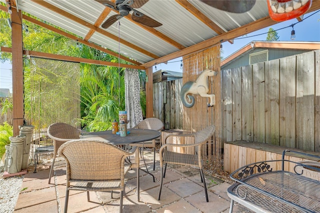 view of patio with outdoor dining area, a ceiling fan, and fence